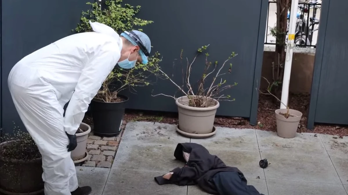 En mann i hvit krimteknikerdrakt ser på en person som man later som er død for å illustrere hvordan er åstedsrapportering kan se ut med KI. 