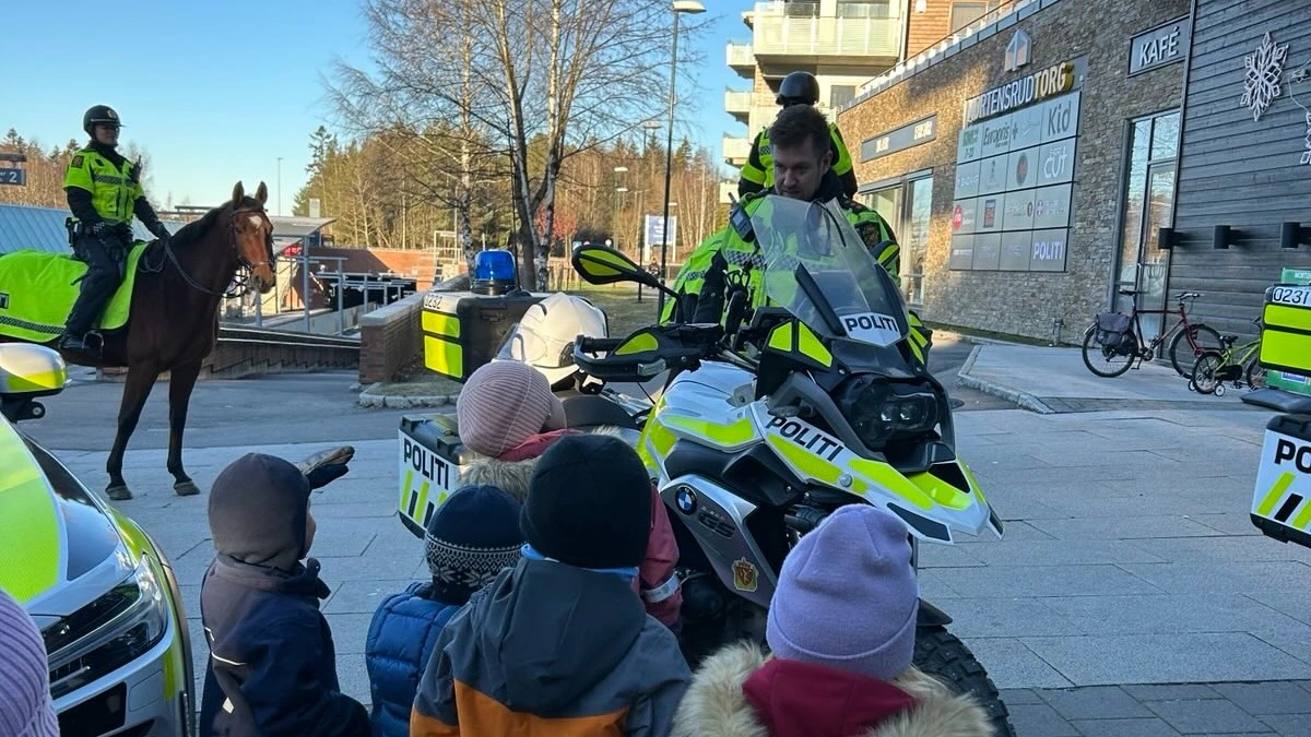 Bildet viser barn som ser på politi-motorsykkel og politihest. 
