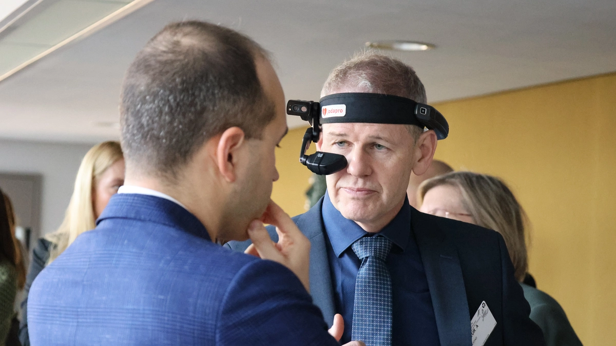 Mann med kamera på hodet. En annen ser på. 