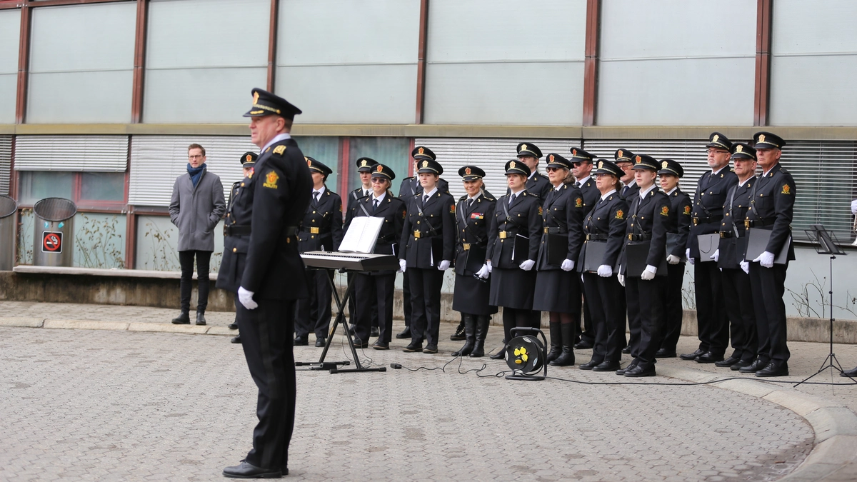 Polititjenestepersoner i uniform synger